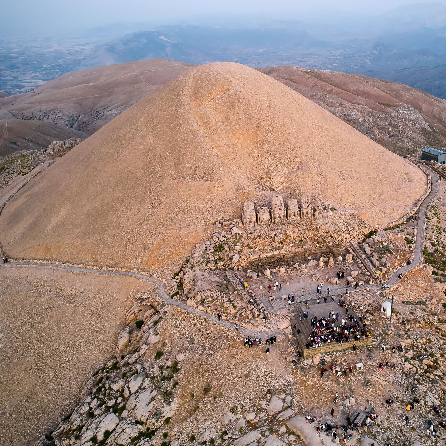 People on Nemrut Mount slope waiting for sunrise. Aerial view. Eastern terrace of Nemrut Mount, Adiyaman province, Turkey. UNESCO World Heritage Site